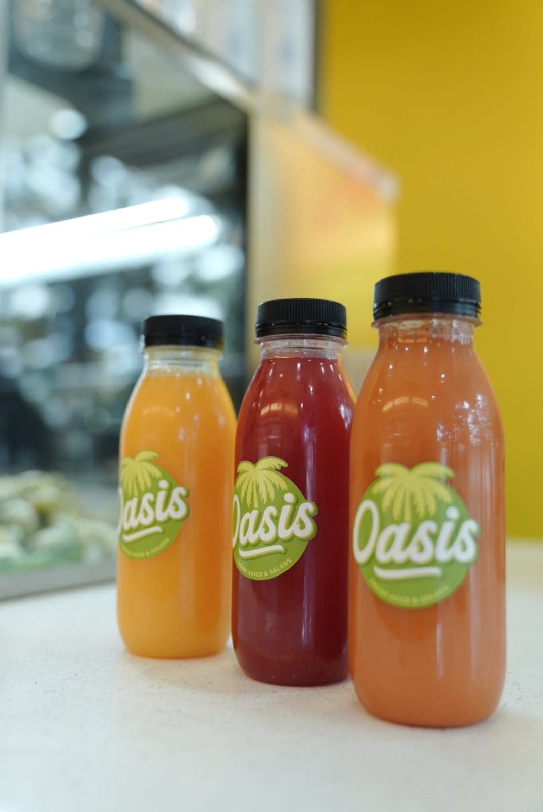 Freshly pressed Oasis juice bottles on the counter